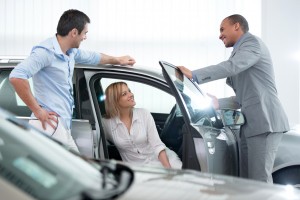 African American car salesperson talking with his customers.